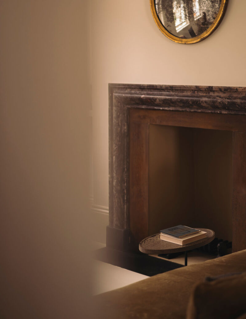 Marble fireplace viewed from Arclinea kitchen in refined contemporary interior